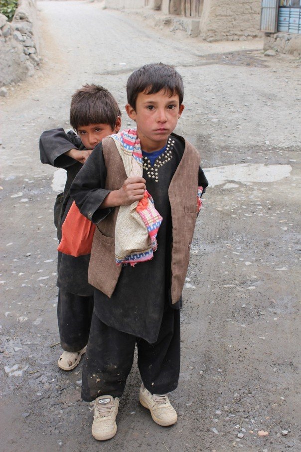 Two poor Afghan children walking on street in Baharak area of Badakhshan in Afghanistan